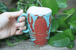 Load image into Gallery viewer, Lobster Lovers Handled Travel Mug, Red Lobster with Pink, Yellow, Purple and White Buoys - 16 oz
